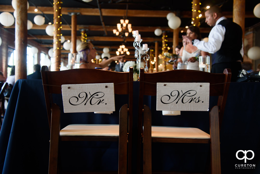 Mr. and Mrs. sign on the back of chairs.