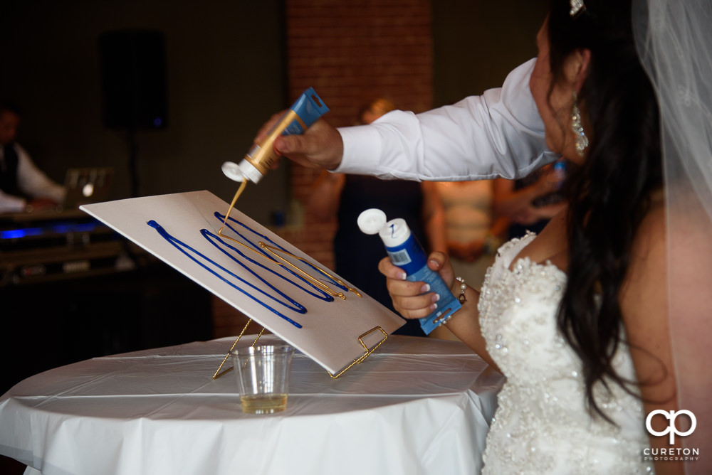 Bride and groom performing a paint ceremony at the reception.
