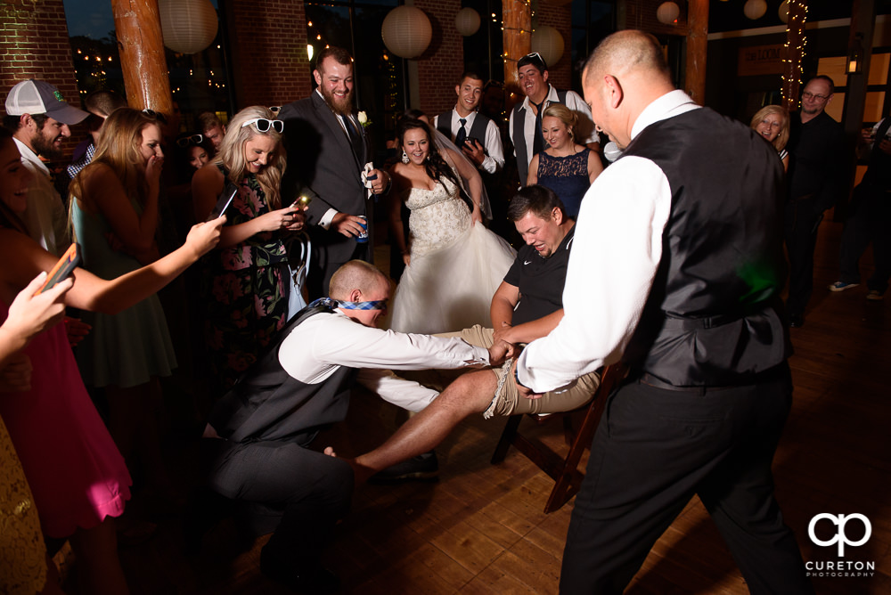 Person who caught the garter putting it on the person who caught the bouquet.
