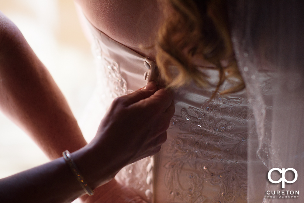 Bride's dress getting zipped.