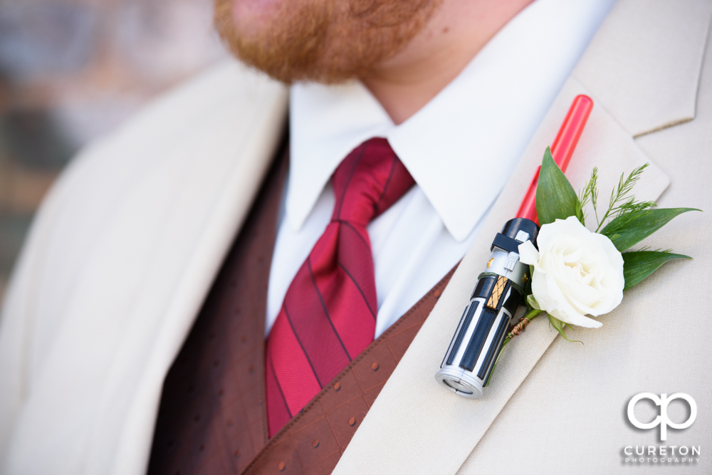 Closeup of Star Wars themed lightsaber boutonniere for the wedding.