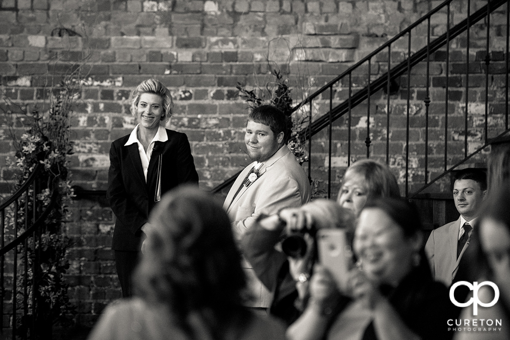 Groom sees his bride for the first time walking down the aisle.