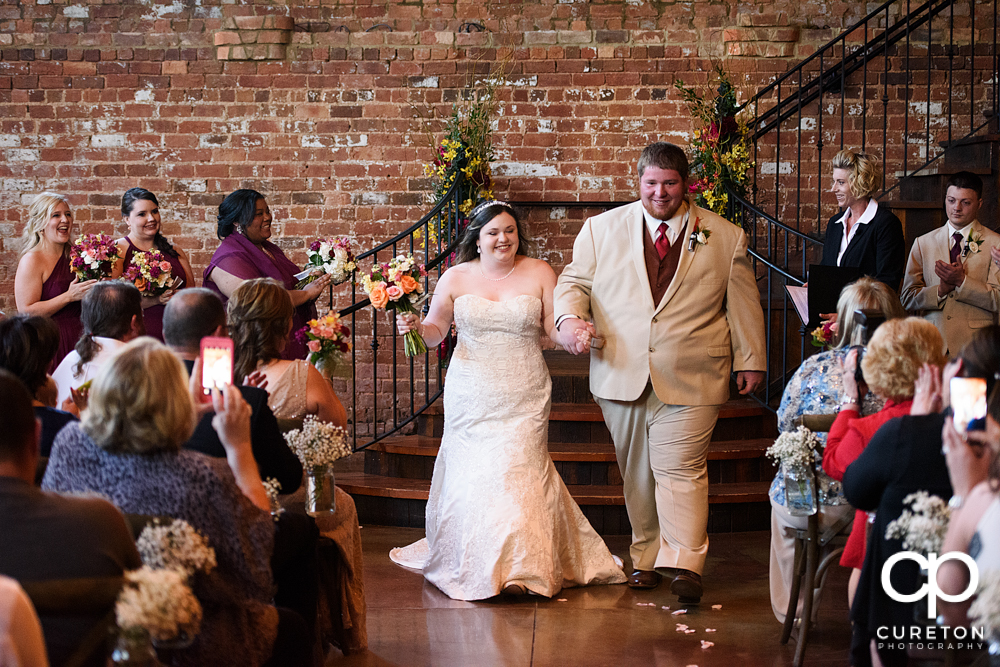 Bride and groom walking back down the aisle.