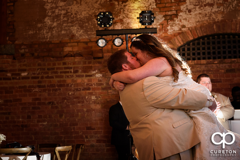 Groom lifting his bride during their first dance.