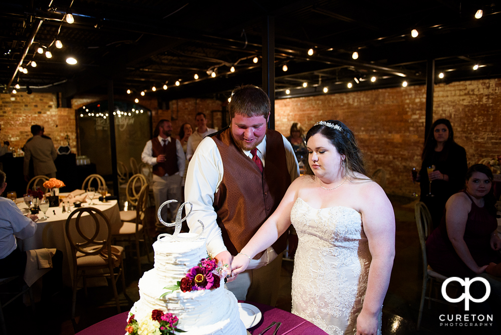 Bride and groom cutting the cake.