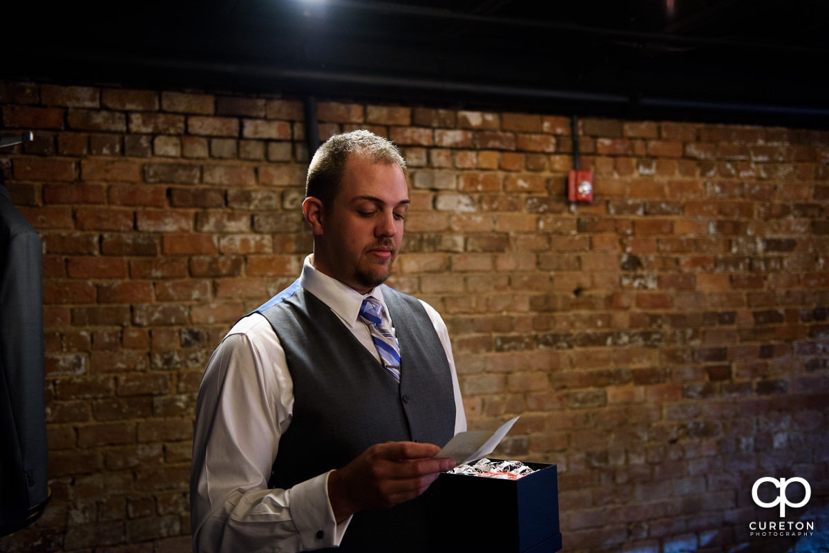 Groom reading a note from his bride.
