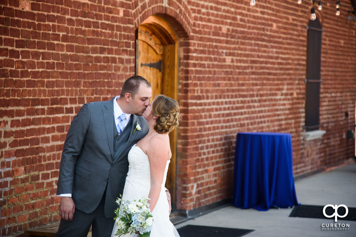 Groom kissing his bride at their first look.