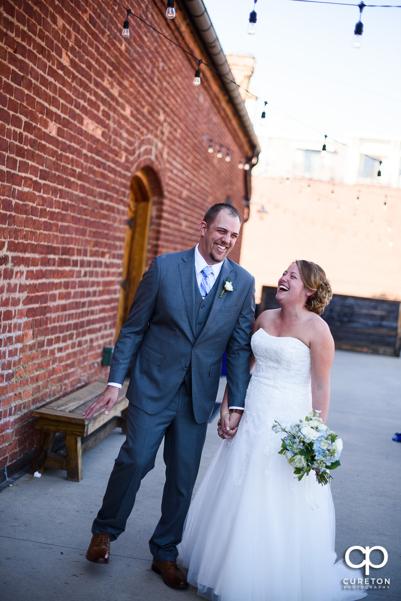 Bride and groom laughing before their wedding at Old Cigar Warehouse.