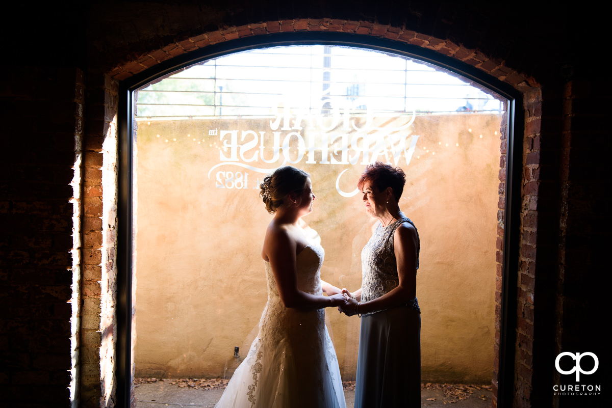 Bride and her mother holding hands before the wedding ceremony at The Old Cigar Warehouse.