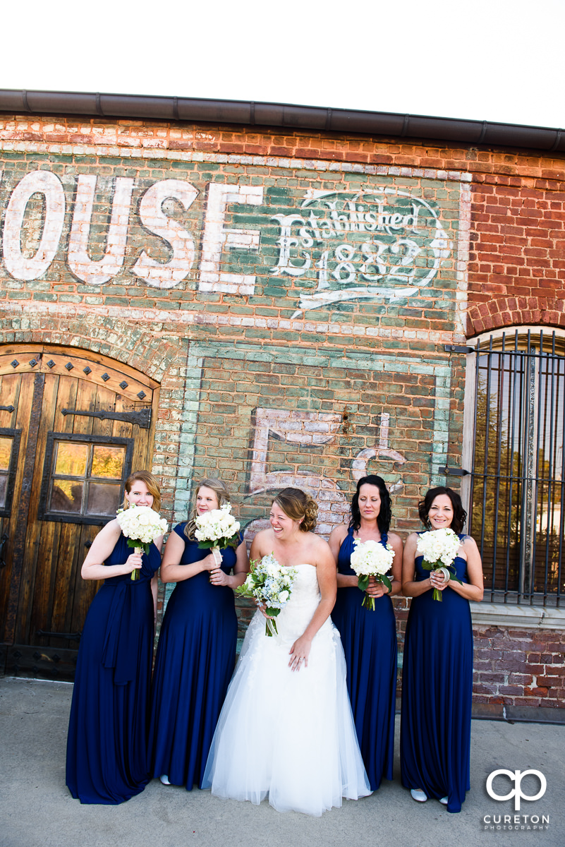 Bride and her bridesmaids laughing on the deck before the wedding at The Old Cigar Warehouse.