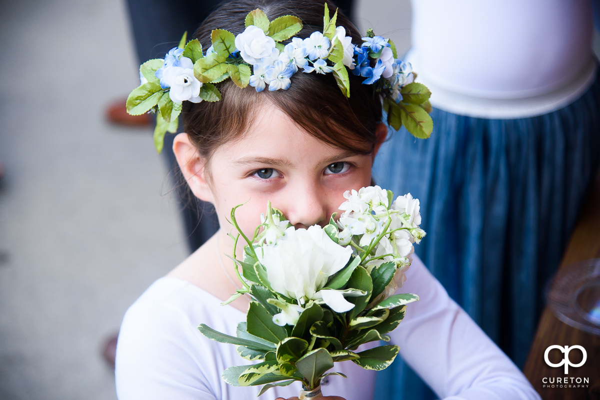 Flower Girl holding flowers where you can only see her eyes.