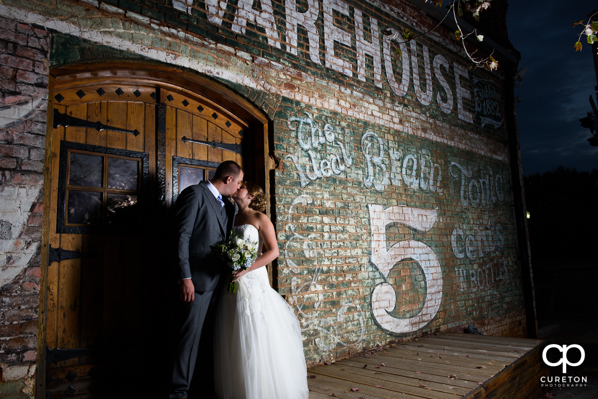 Bride and Groom kissing at night outside the Old Cigar Warehouse.