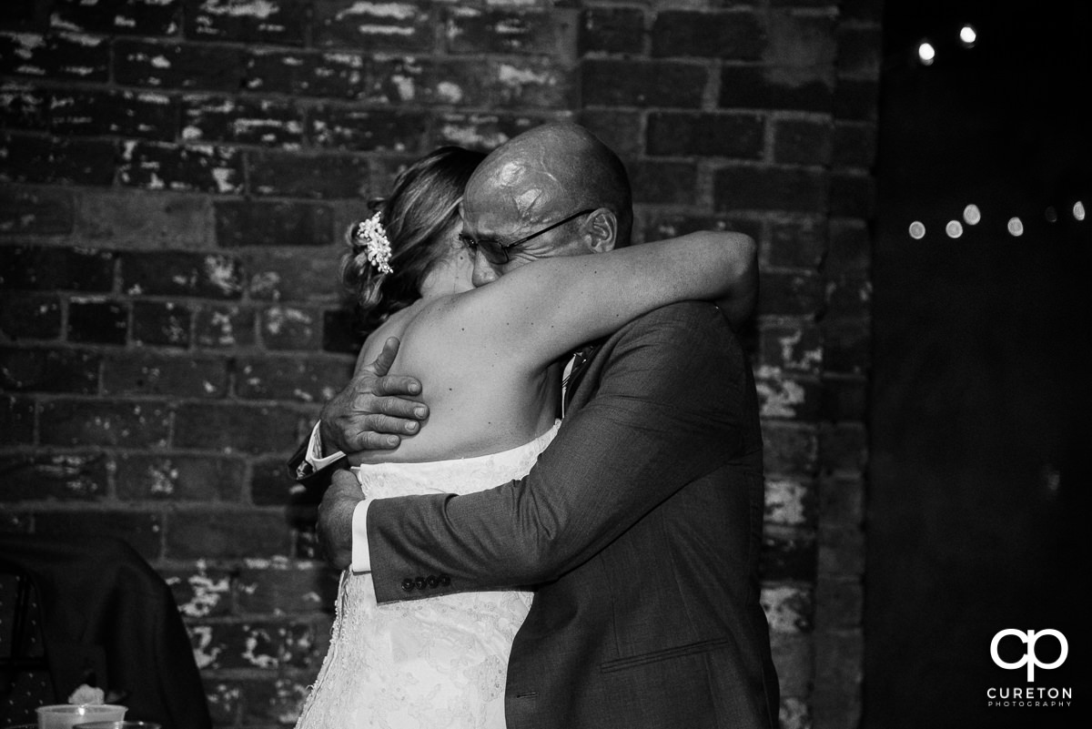 Bride hugging her dad after a heartfelt speech.
