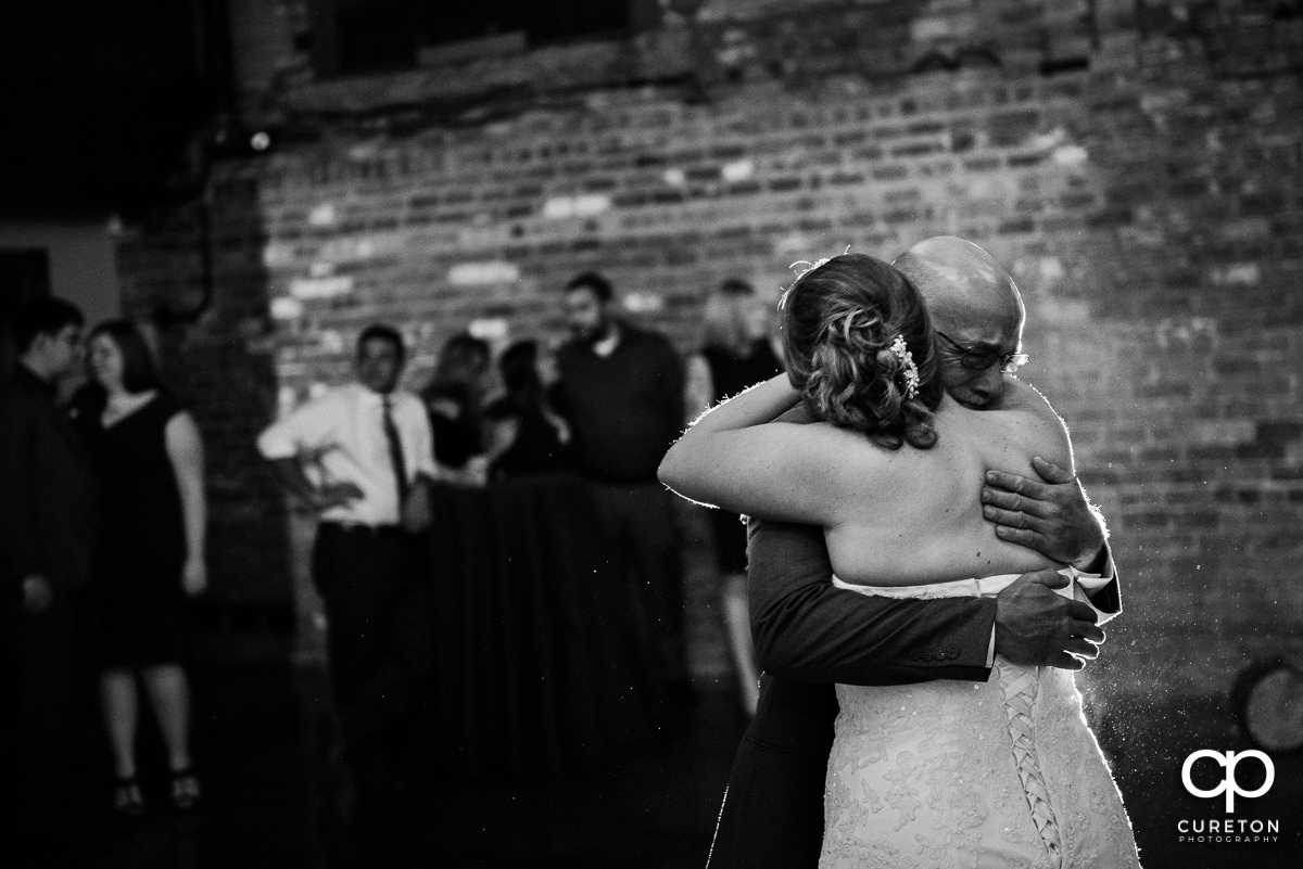 Bride and her dad hugging.