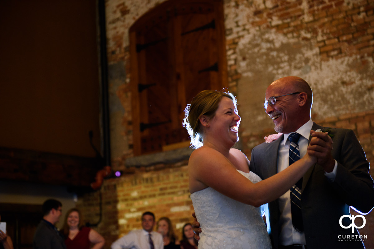 Bride and her father laughing during their dance at the reception.