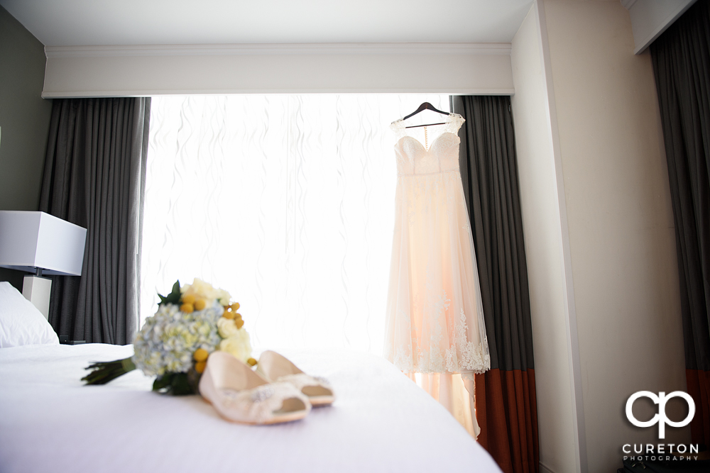 Bride's dress hanging in the window of Embassy Suites River Place.