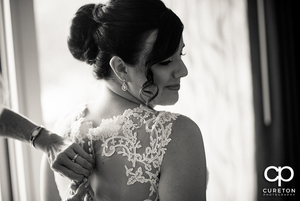 Bride putting on her dress.