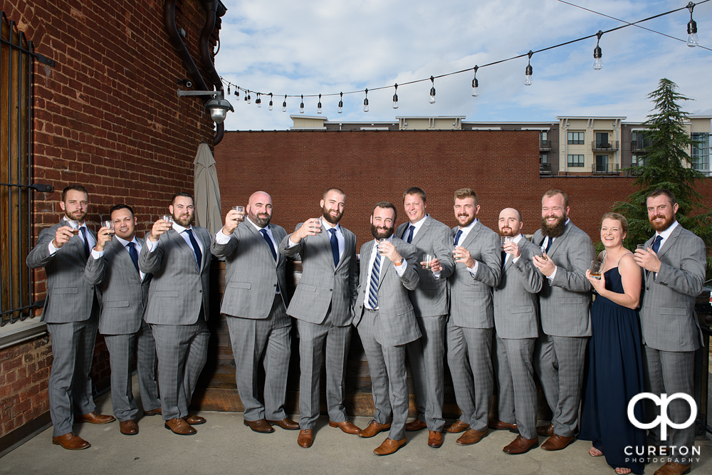 Groom and groomsmen having a drink on the deck of the old cigar warehouse.