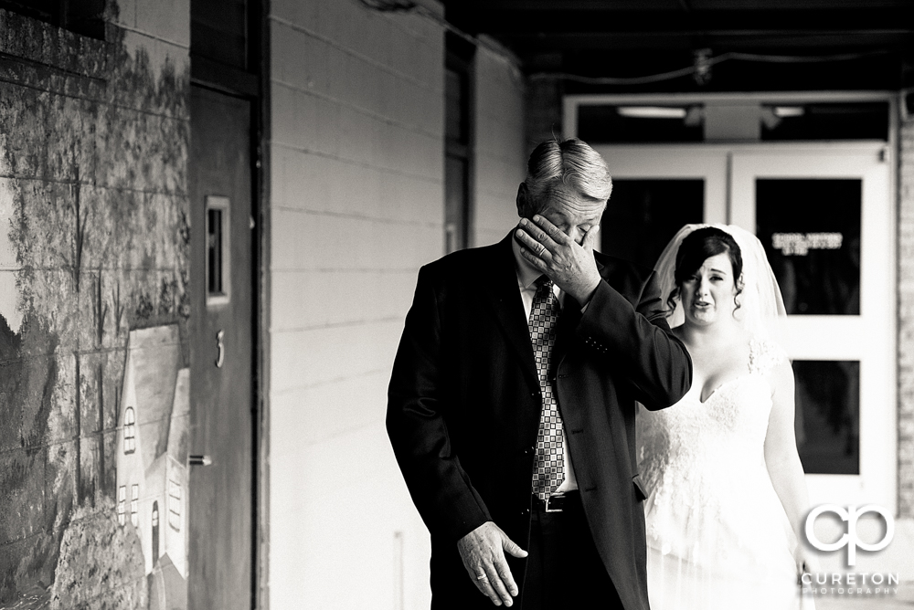 Brides father sees his daughter for the first time in the dress.