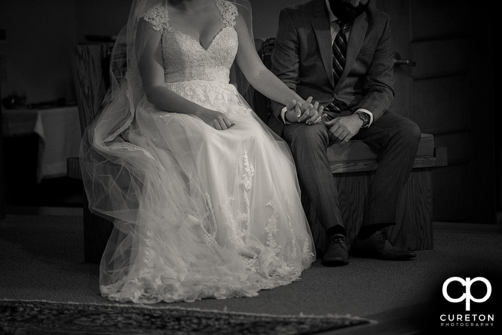 Bride and groom holding hands during the ceremony.
