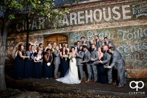 The entire wedding party posing for photos outside the old cigar warehouse in downtown Greenville.