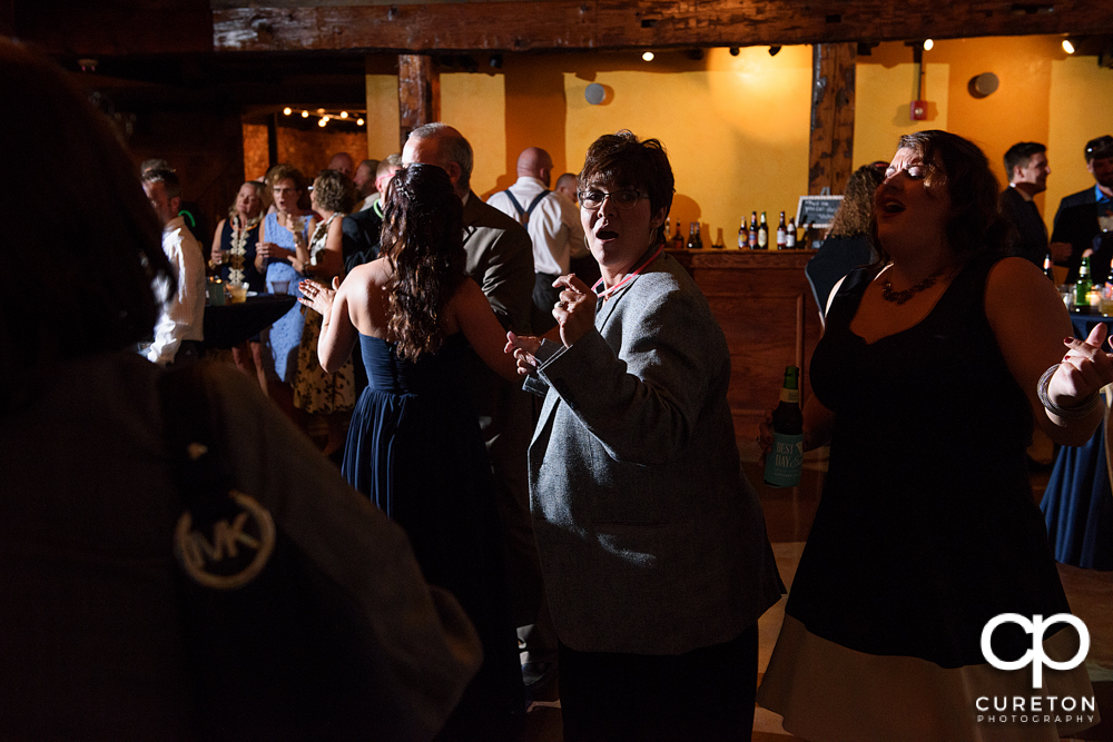 Guests dance at the wedding reception at the old cigar warehouse in downtown Greenville as the party machine djs.
