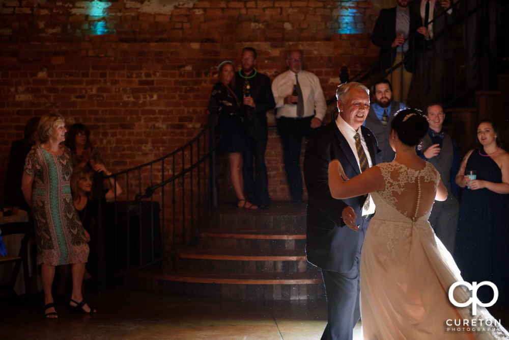 The brides father dancing with his daughter.