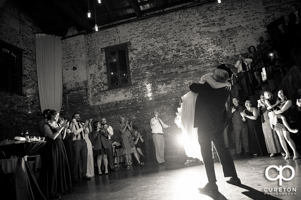 The bride and her father hugging on the dance floor at her wedding reception.