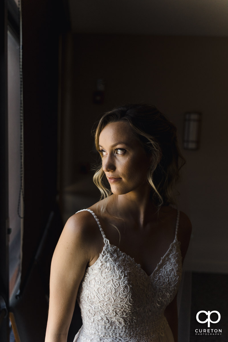 Bride looking out of a window before her ceremony.