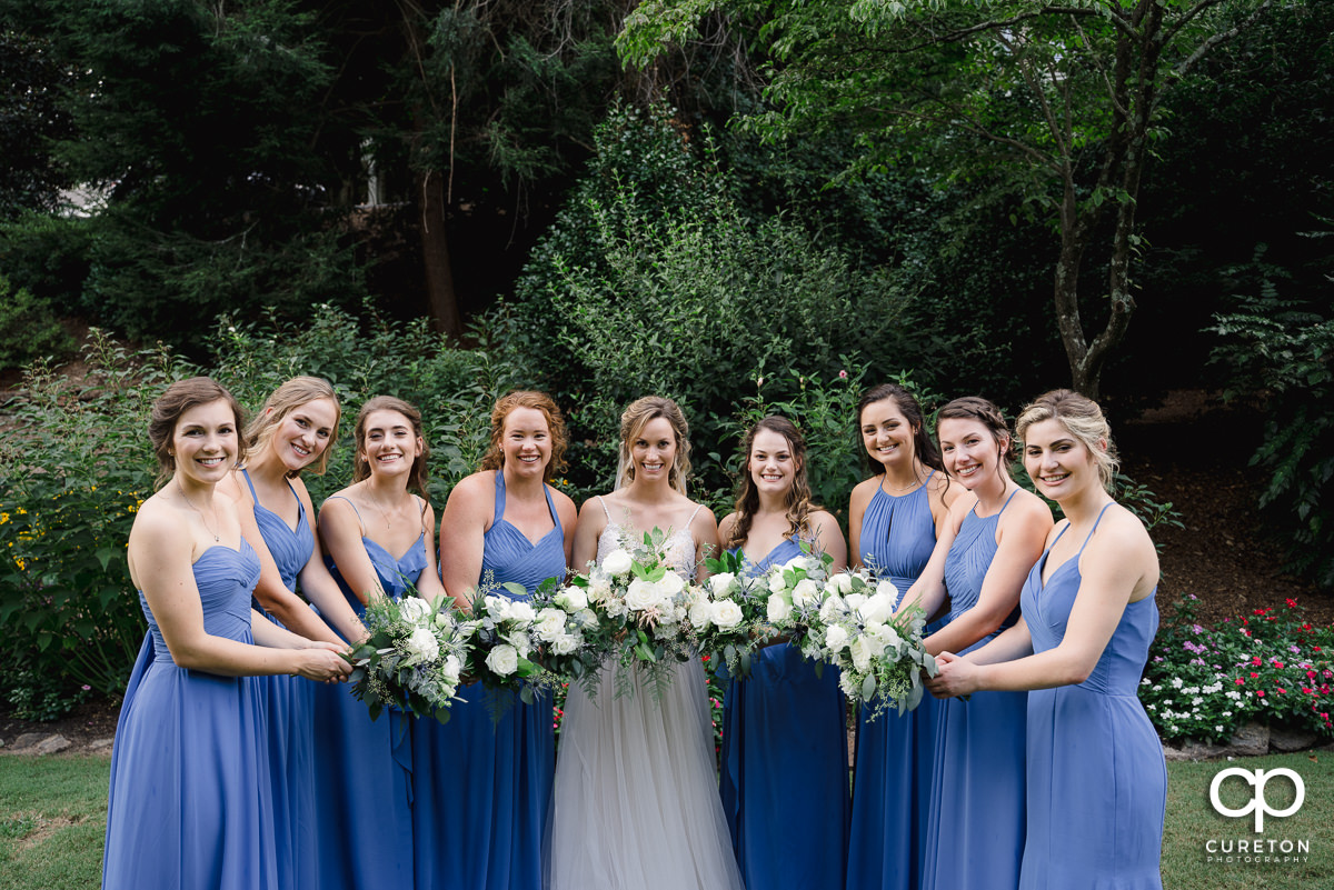 Bridesmaids holding out their flowers.