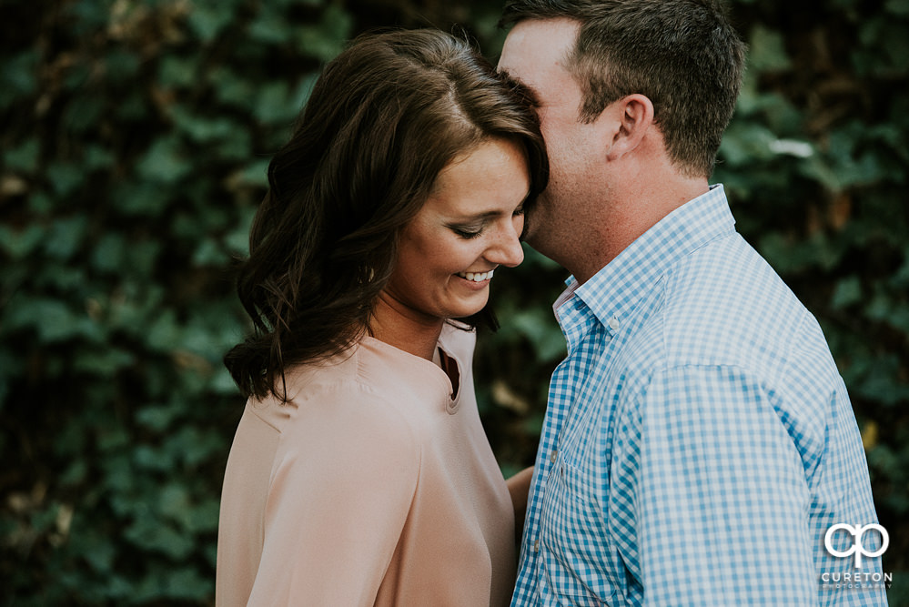 Engaged couple walking through the park during a west end Greenville, SC engagement session.