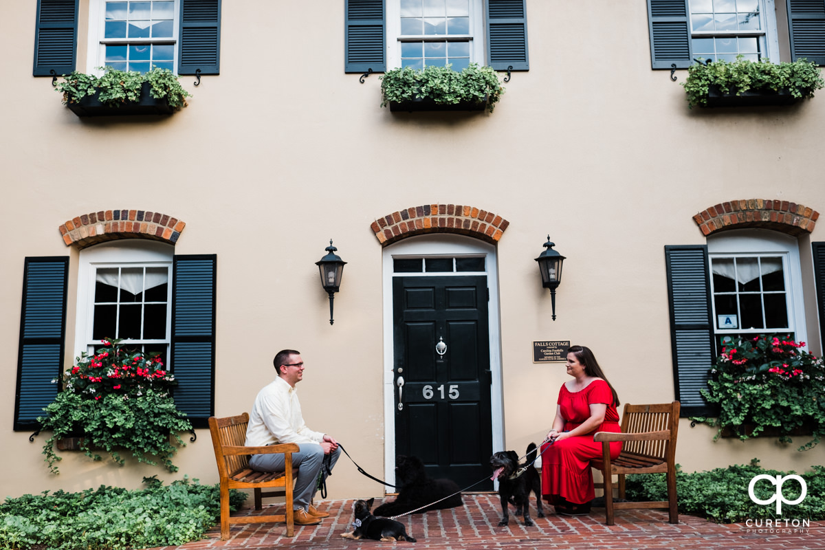 Man and woman with their dogs in front of Mary's cottage in downtown Greenville,SC.