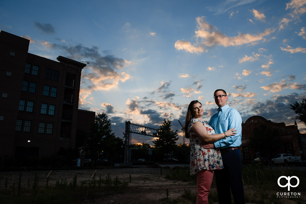 Engaged couple strolling though west end Greenville SC at sunset during an engagement session.