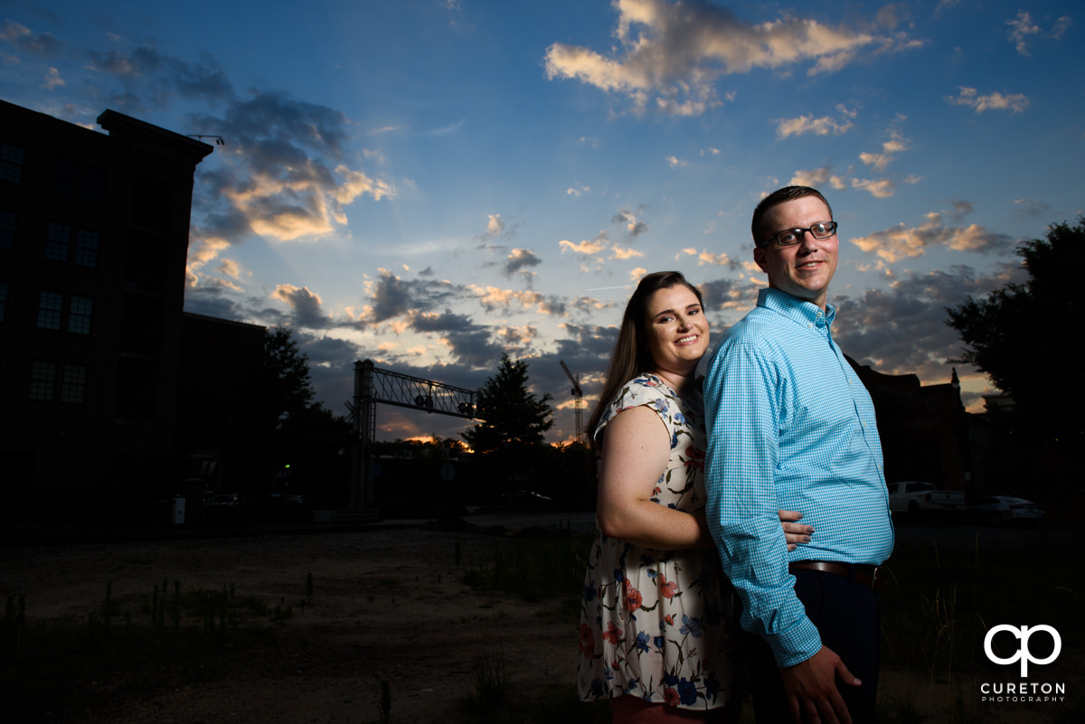 Future bride and groom cuddling at sunset during an engagement session in West End Greenville,SC