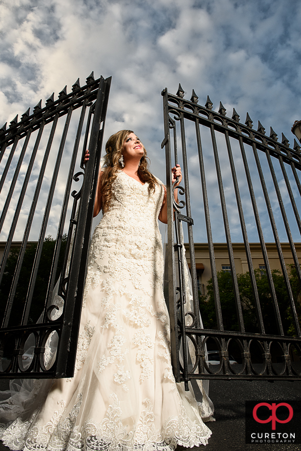 Bride holding onto an iron gate in downtown Greenville,SC during a bridal session.