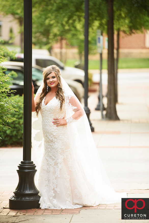 Bride leaning on a light pole in downtown Greenville,SC.