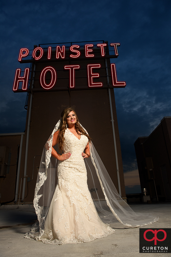 Bride on the roof of the Westin Poinsett near the sign during a pre wedding bridal session in Greenville,SC.