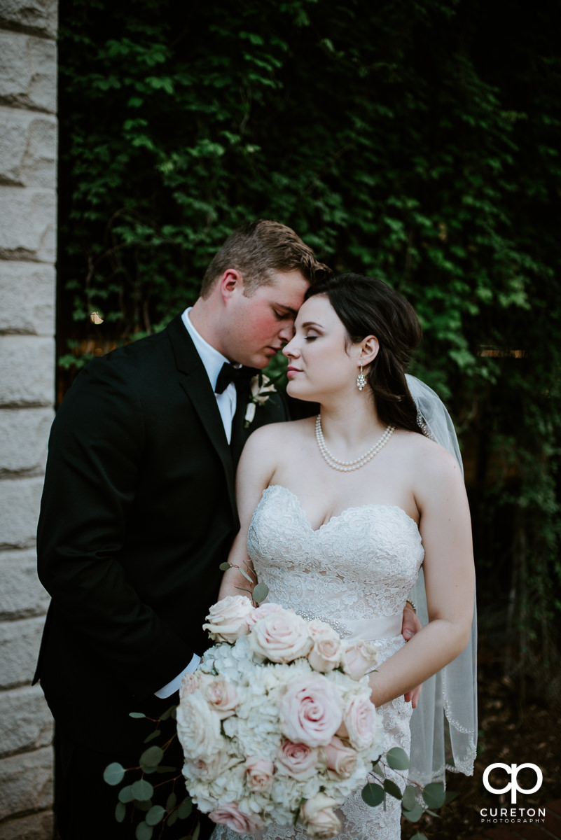 Groom snuggling with his bride on the streets of Greenville SC after their Westin Poinsett Hotel Wedding.