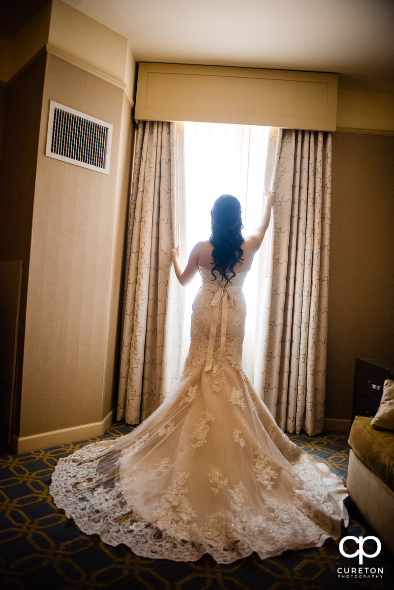 Bride standing in a window at the hotel.