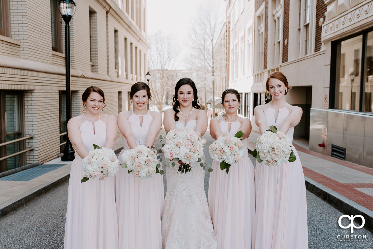 Bride and the bridesmaids holding their flowers.