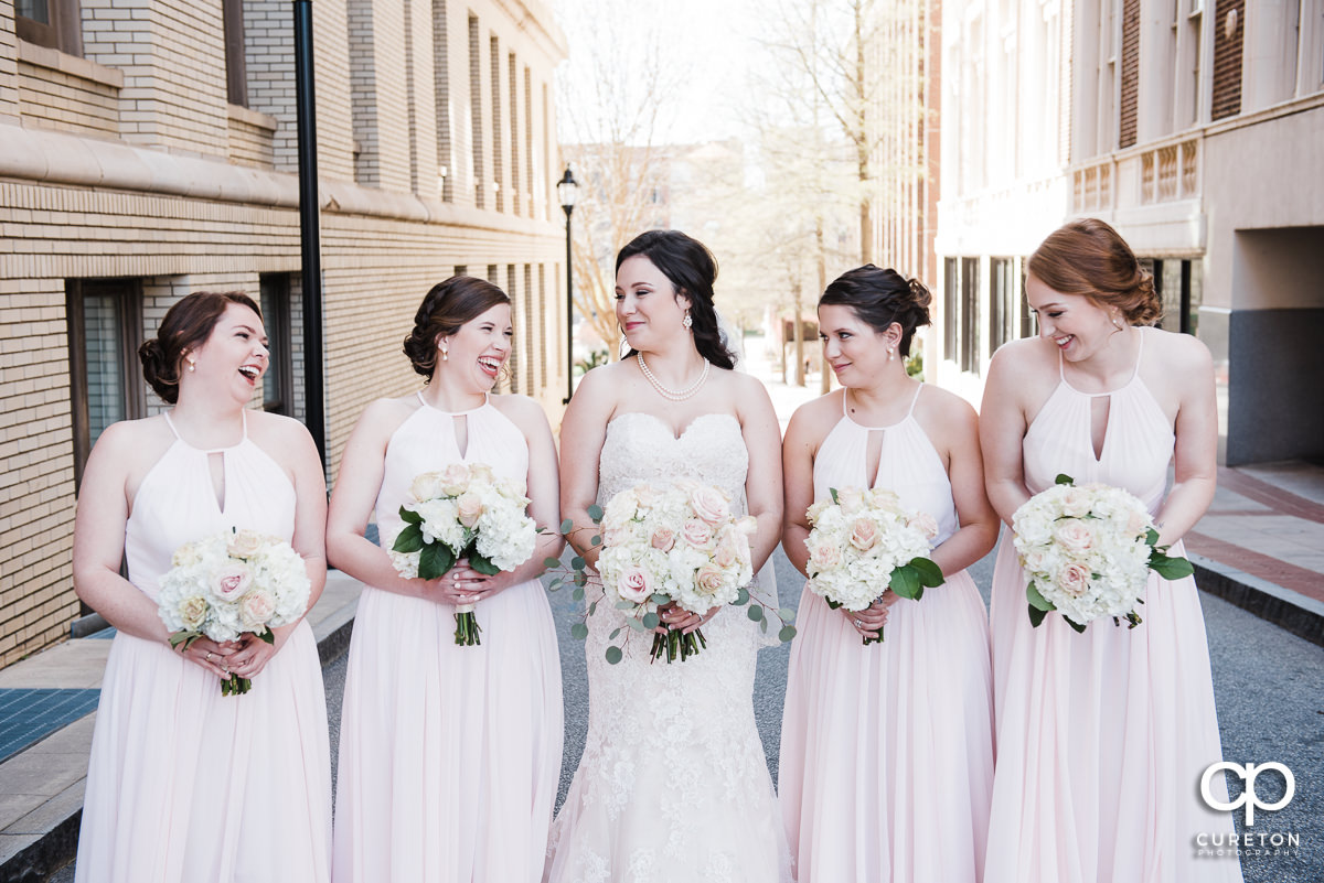 Bride and bridesmaids laughing.