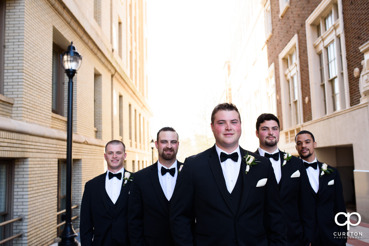 Groom and groomsmen in the alley beside the hotel.