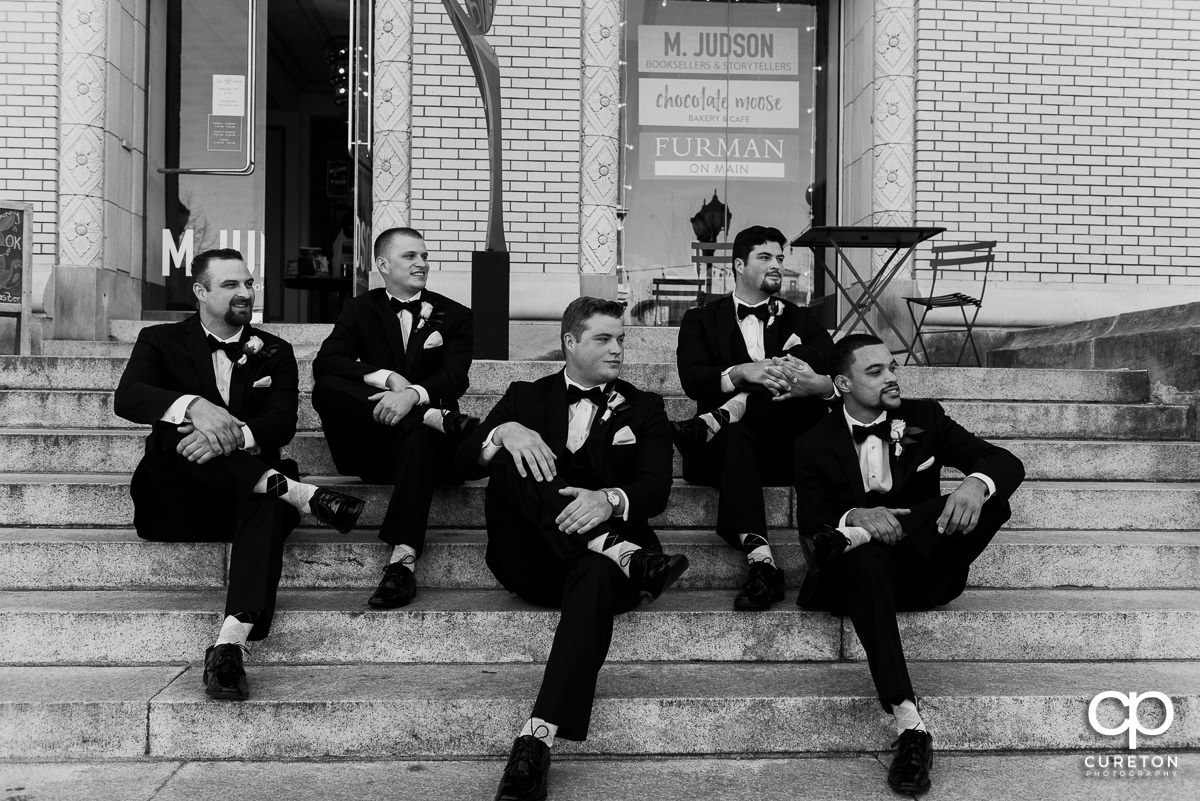 Groom and groomsmen sitting on steps beside the Poinsett Hotel.