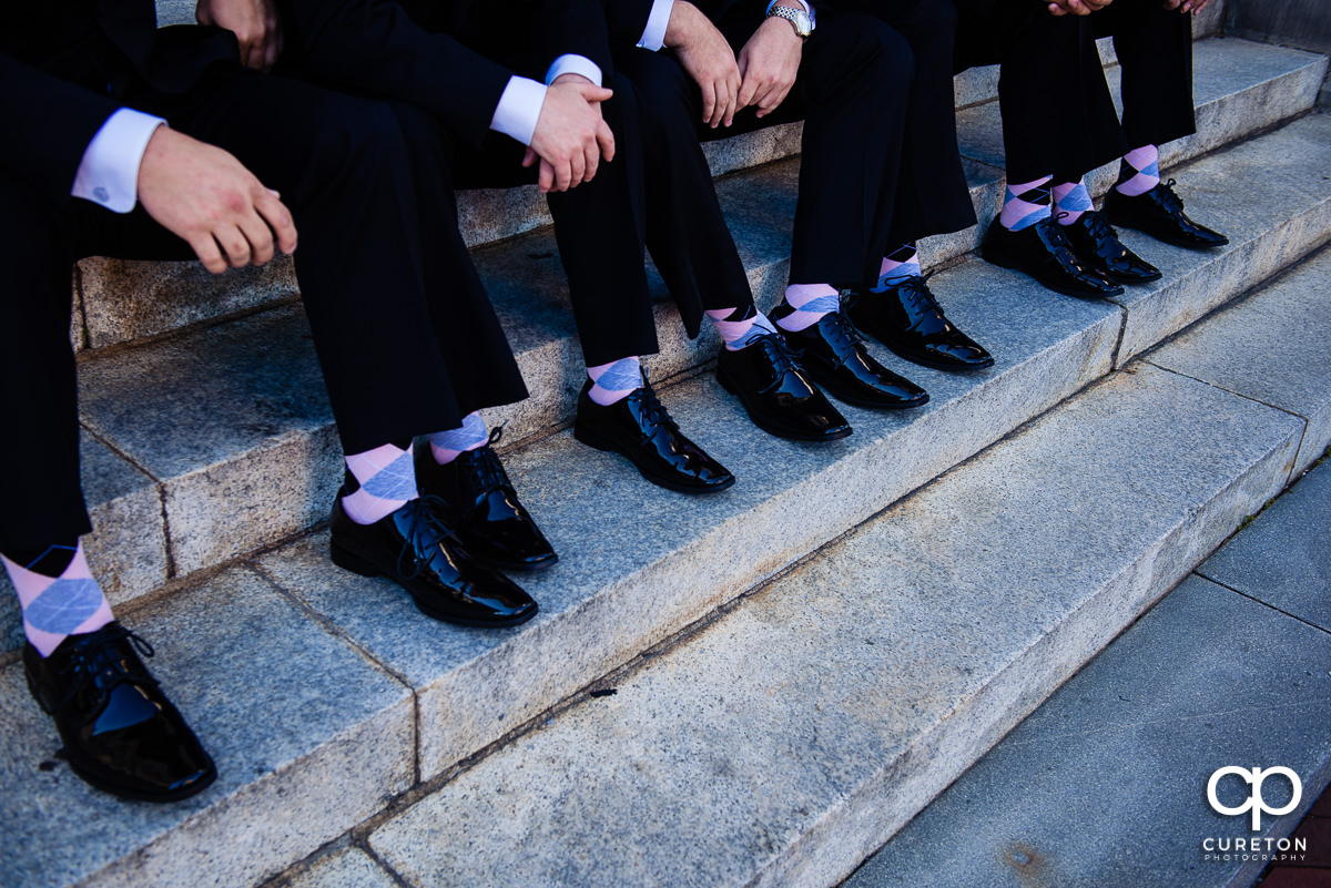 The groom and groomsmen all wearing pink socks.