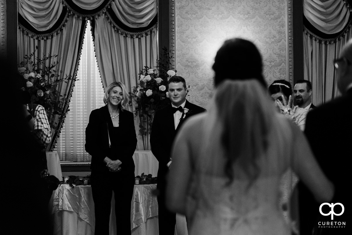 Groom sees his bride going down the aisle for the first time at The Westin Poinsett wedding ceremony.