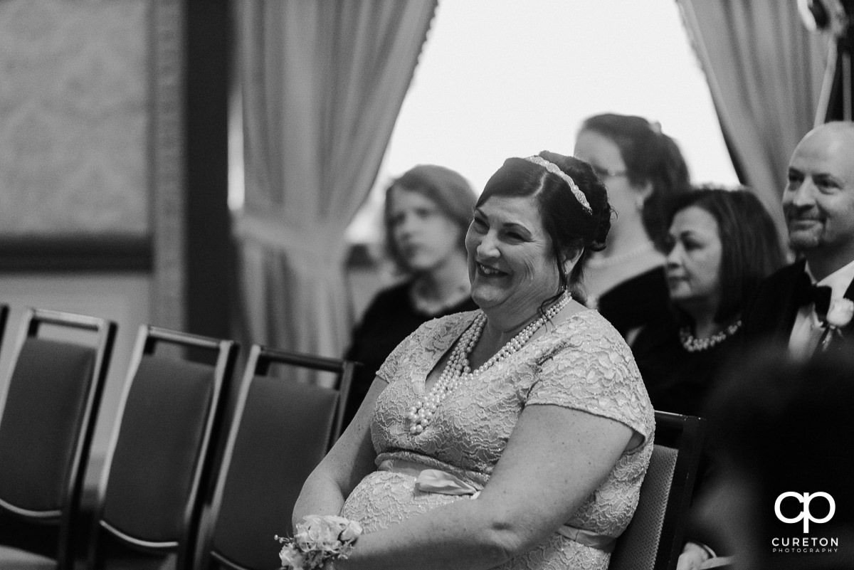 Groom's mother smiling during the ceremony.