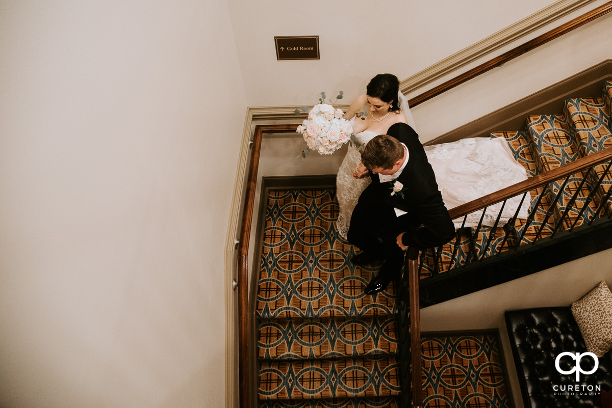Bride and groom walking down the stairs at the Westin Poinsett after the ceremony.