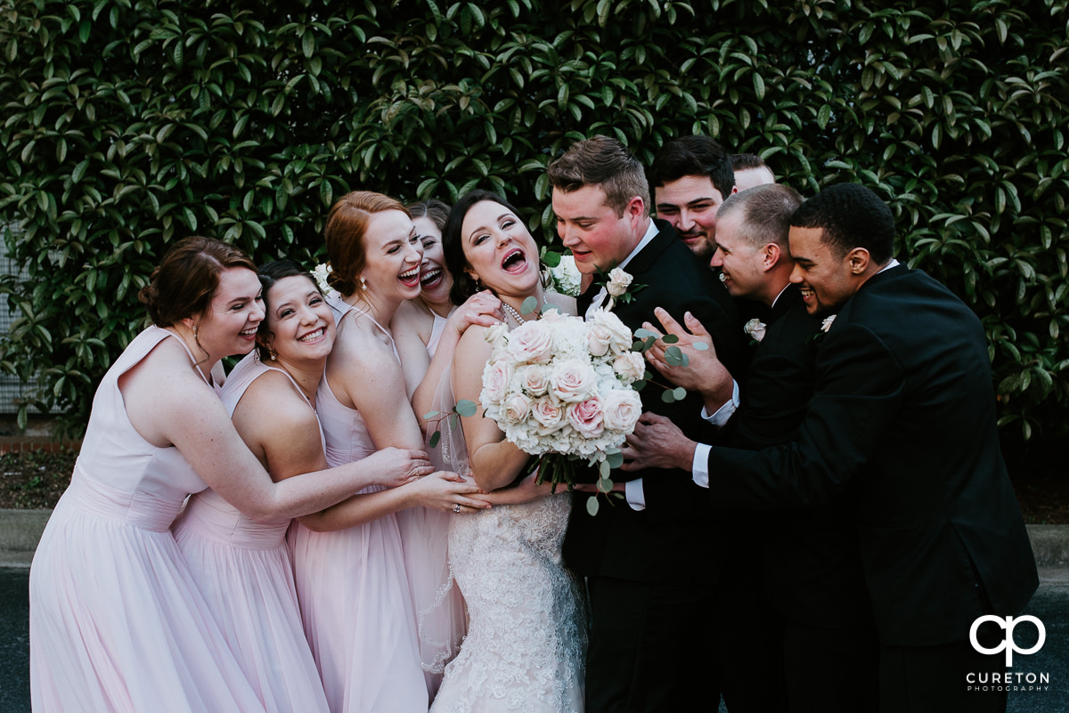 Bridal party hugging the bride and groom after the wedding ceremony at The Westin Poinsett Hotel in Greenville,SC.