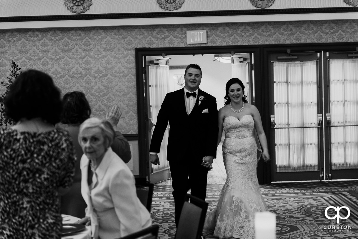 Bride and groom making an entrance to the reception.