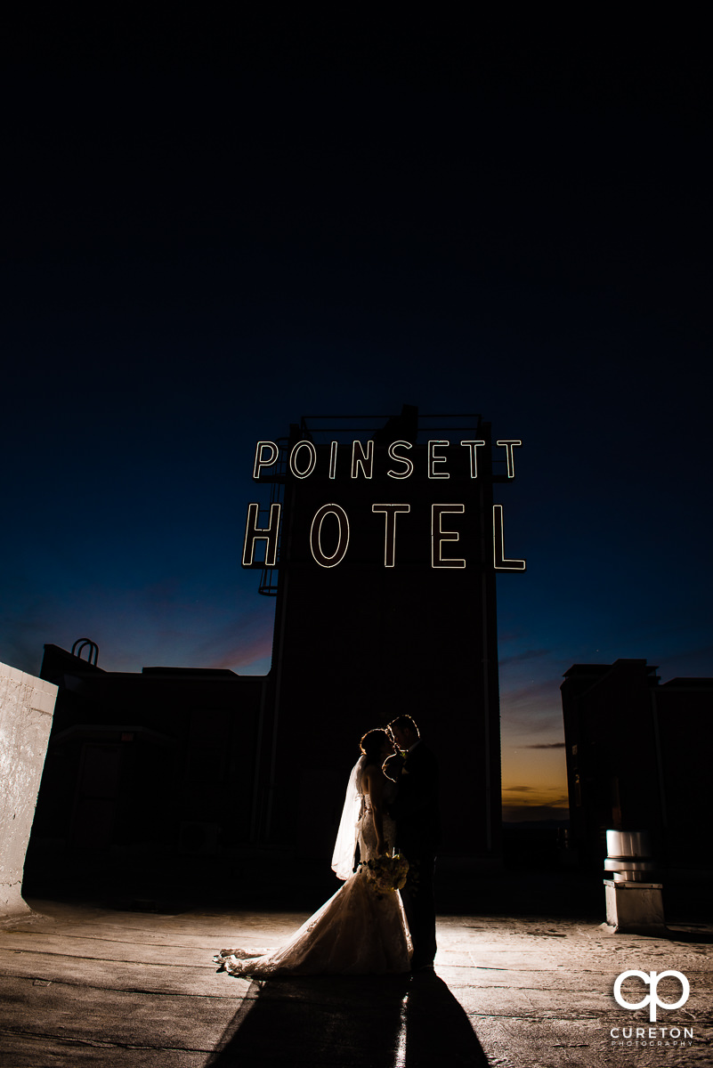 Bride and groom in front of the sign on the rooftop of The Westin Poinsett Hotel in Greenville,SC.